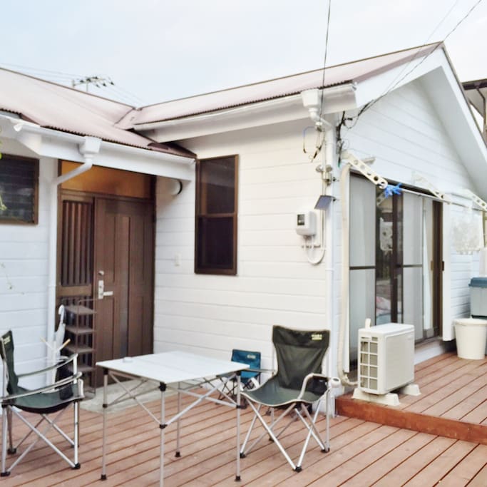 The wooden deck has a table and chairs.Body board.