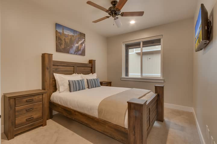 חדר שינה עם מיטת קווין סייז וטלוויזיה עם מסך שטוח.