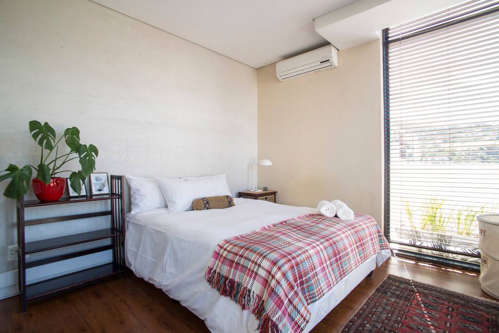 Main bedroom with queen bed, AC and built in cupboards