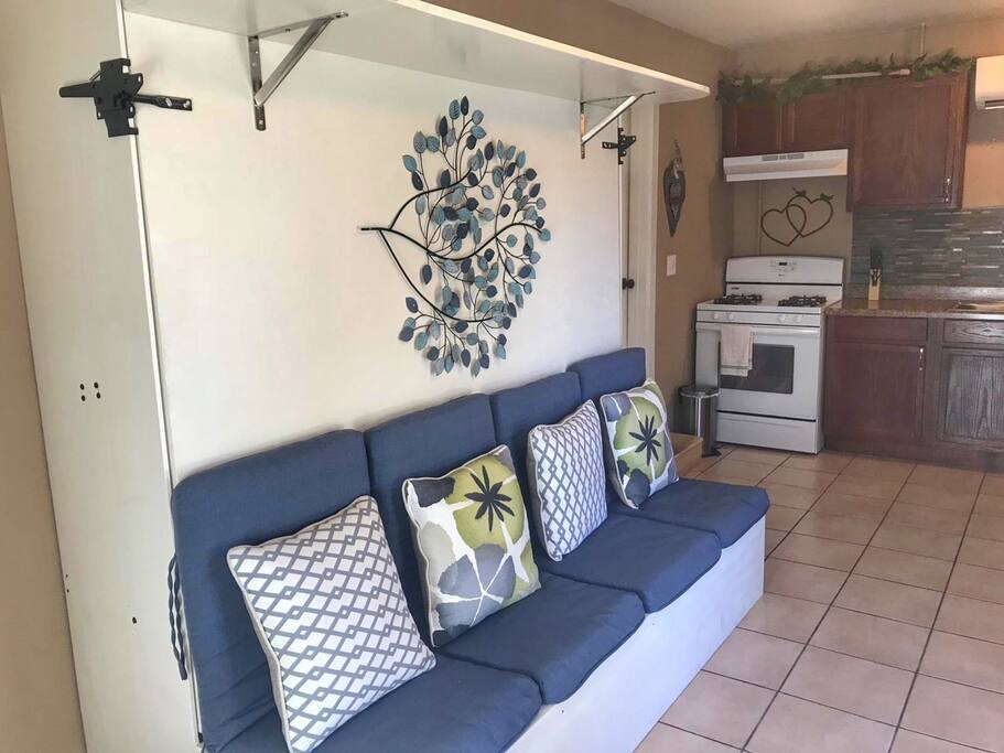 The sofa opens up to a full size queen bed that is mounted to the wall.