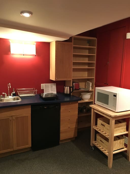 Kitchenette includes microwave, induction stovetop, fridge, sink, kettle, toaster. Kitchen utensils and crockery for four guests.