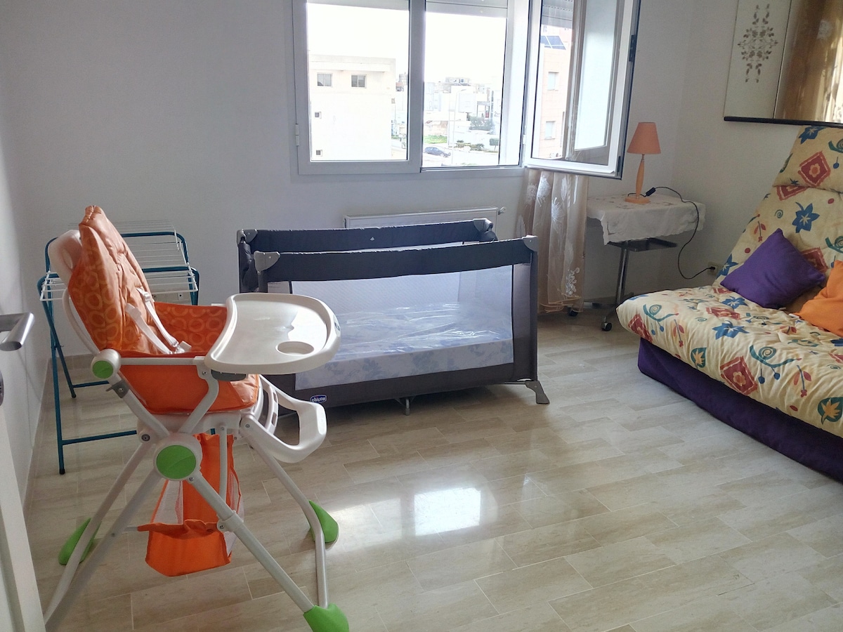 עריסה לנסיעות וכיסא אוכל לתינוקות בחדר האורחים