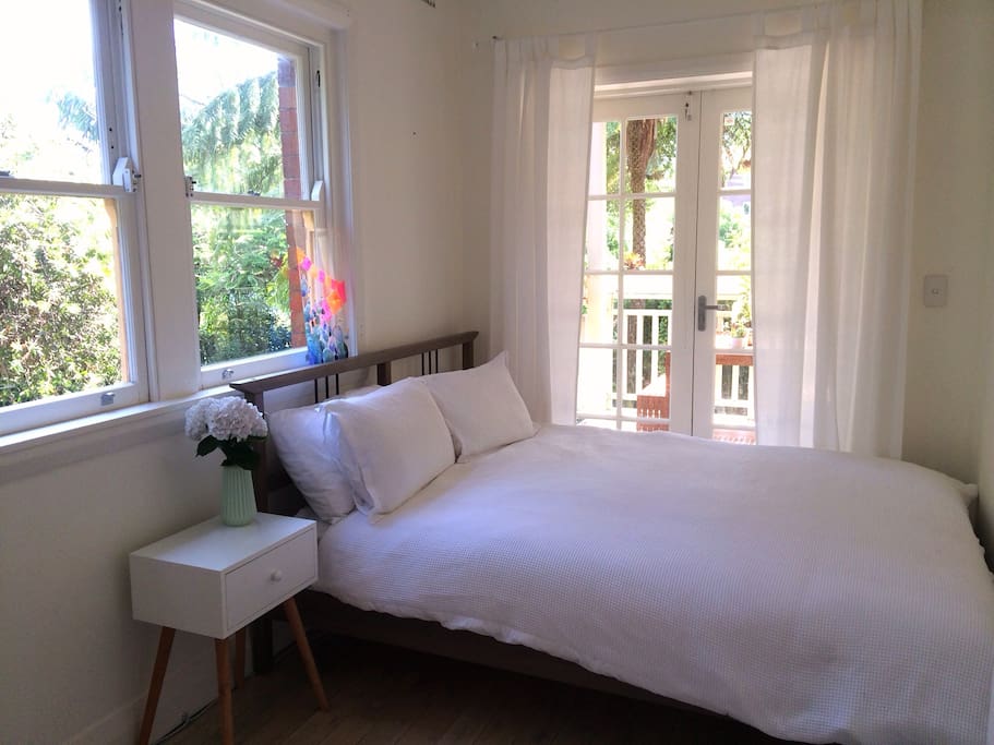 Bright second bedroom with tranquil views onto the deck and garden.