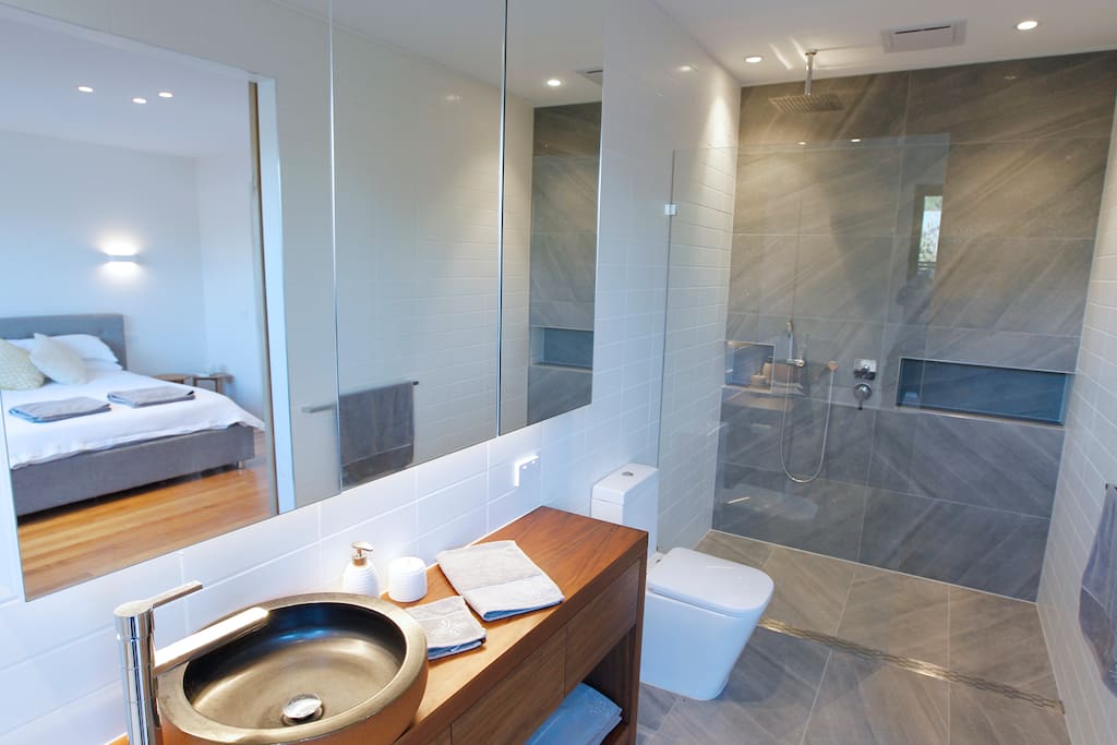5 Star Ensuite Bathroom with big mirrors and luxury overhead rain shower open to Master bedroom with quality linen provided.