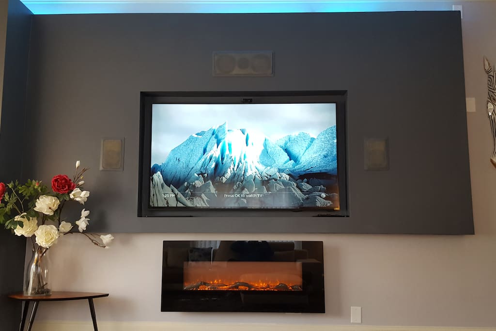 Built in houses 75" TV, surround sound and Ambient (not heating) fireplace