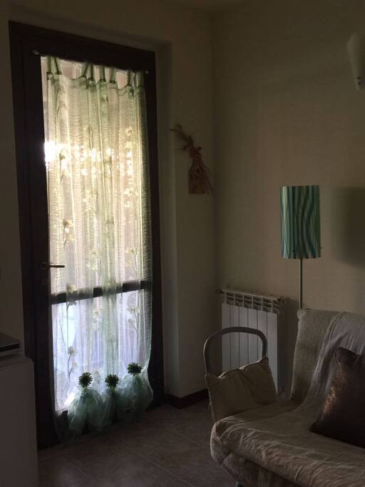 Ingresso con porta a vetro che da sulla veranda e sul giardino