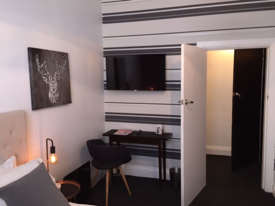 Bedroom 1 has a desk, Smart TV, fridge