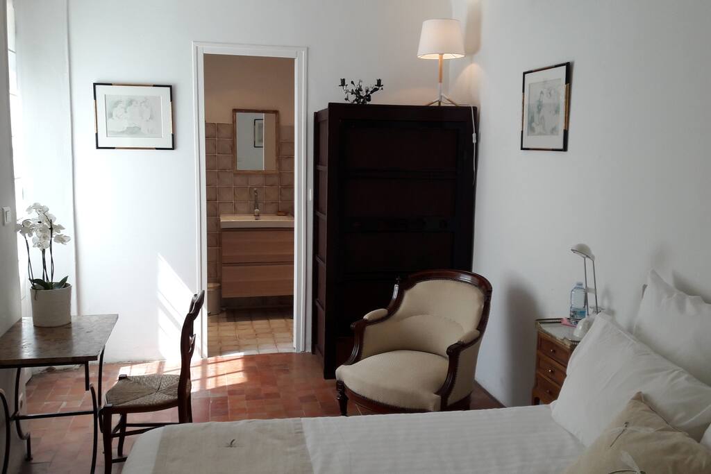 La chambre avec sa salle de bain au fond