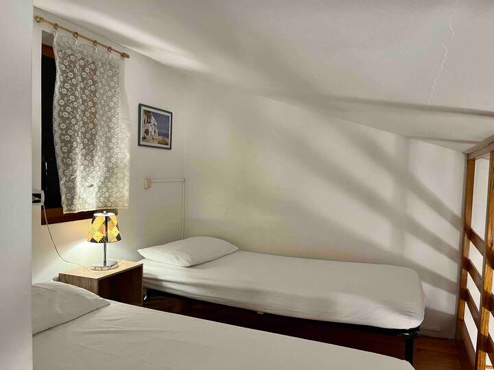 Loft de madera con dos camas individuales y ventilador con control remoto