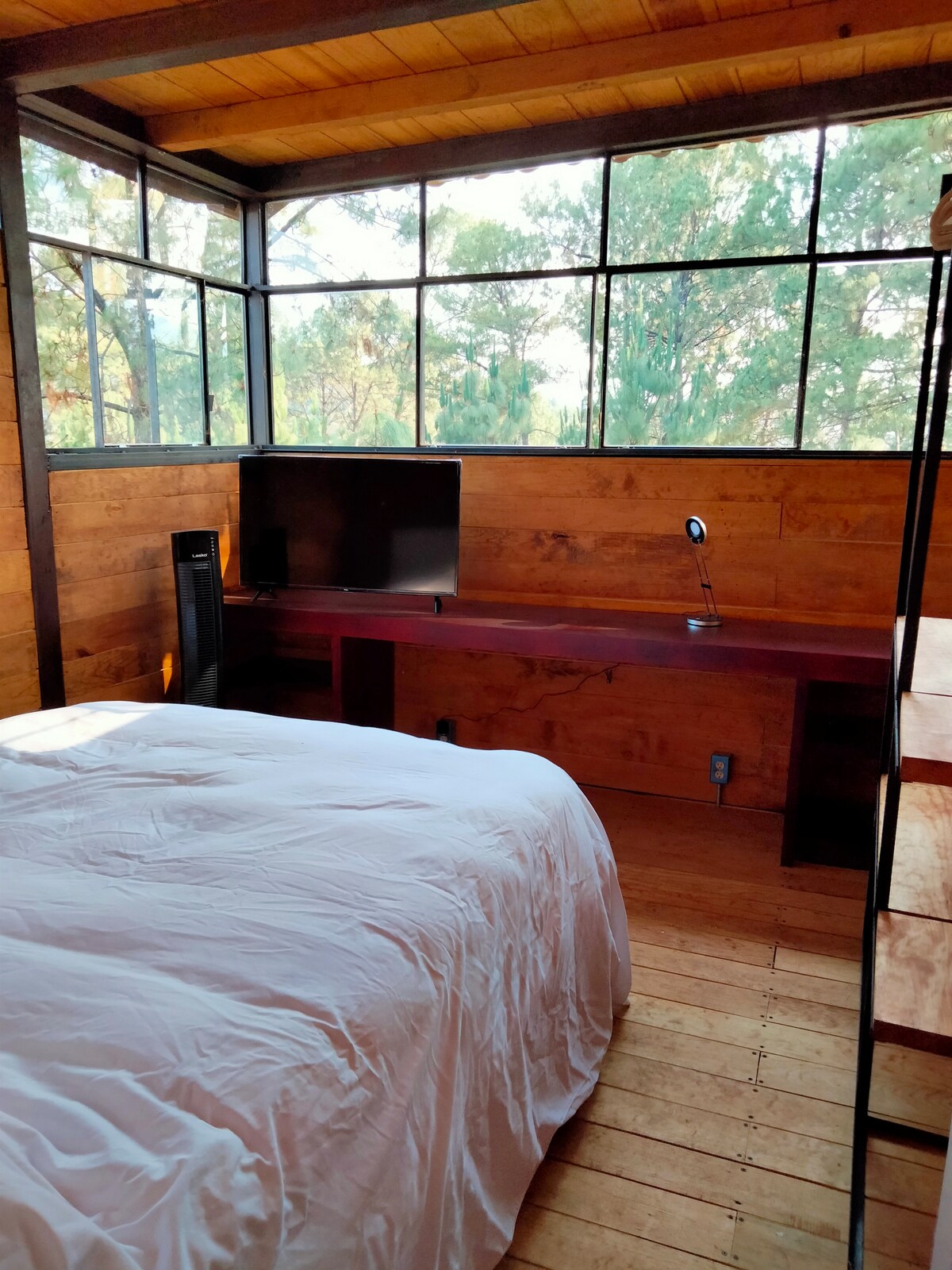 חדר שינה עם טלוויזיה חכמה ושולחן עבודה