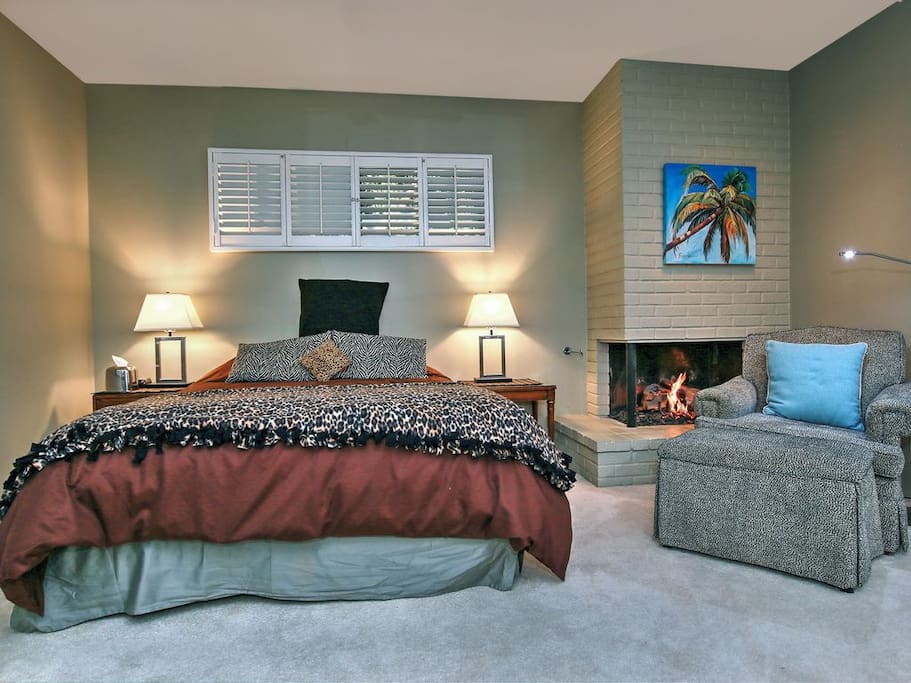 A luxurious queen bed & comfy chair for enjoying the fireplace