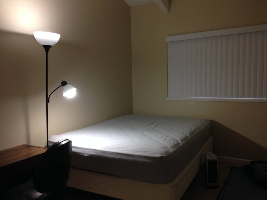 Bed inside the room with table and lamp