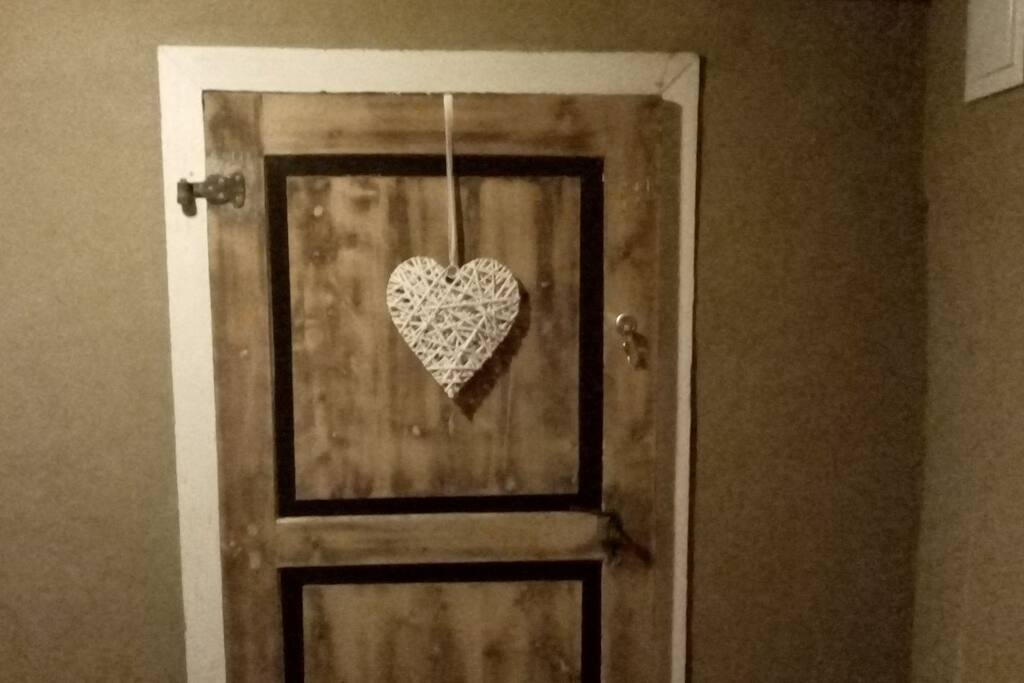 Der Flur ist mit Naturlehm verputzt. Hier durch die neu abgebeizte Tür geht es in ihrer Wohnung.