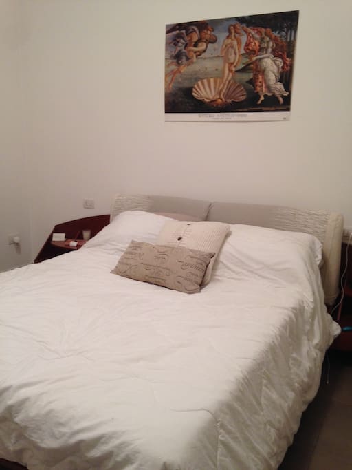 Bedroom with queen sized bed and plenty of storage space, plus a balcony overlooking the street