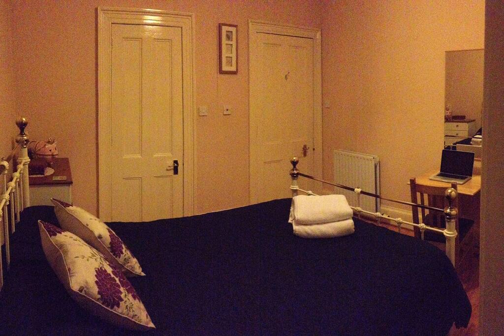 Comfy double bed, mirror and computer desk.