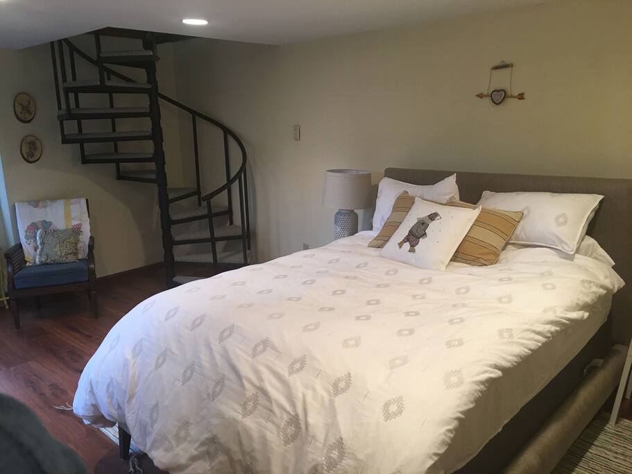 Walk down carpeted spiral staircase to bedroom.