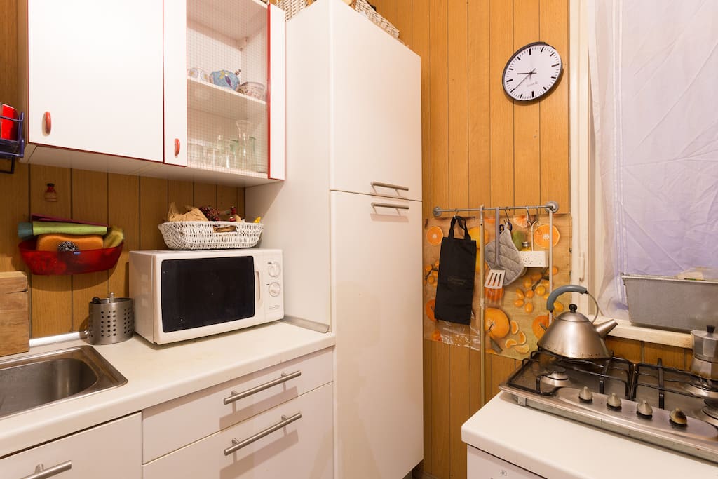 small kitchen with fridge, oven and gas stove