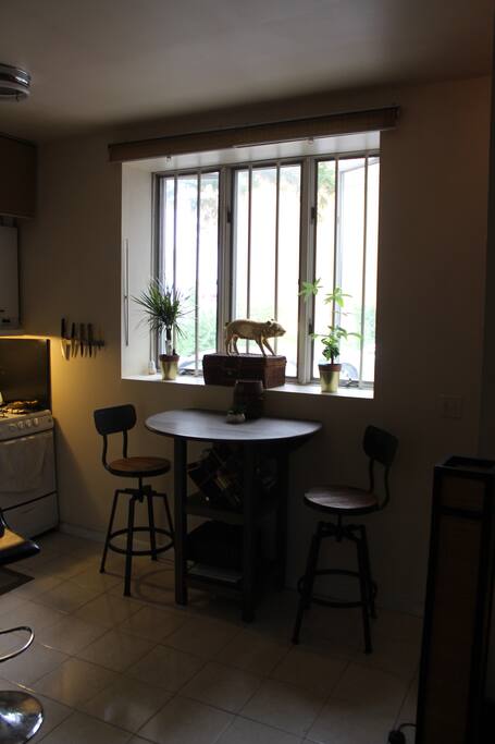 Kitchen Area with bar/ standing table with chairs to have breakfast by the large window or just to read a book.