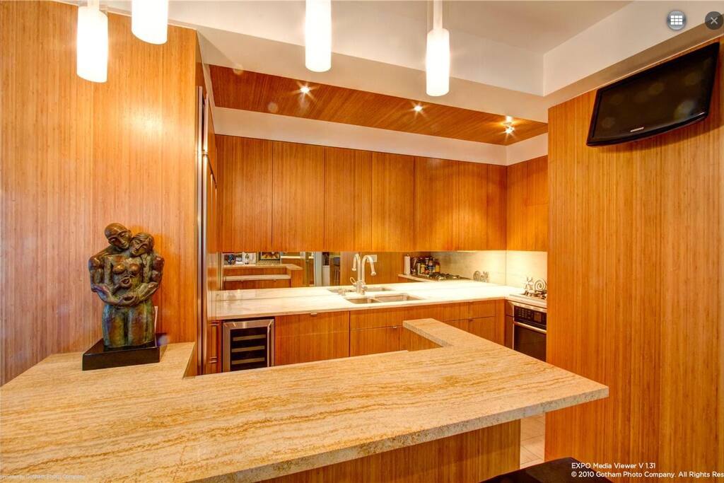 Travertine Kitchen Island with Marble Countertop, Wine Cooler, Subzero Fridge, and all the modern accents