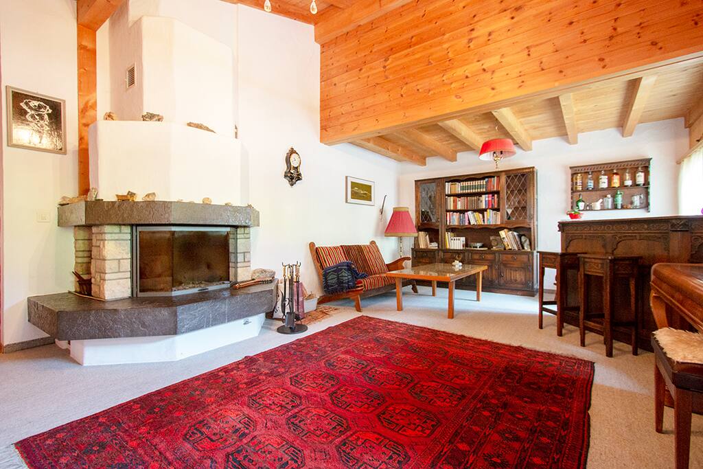 Grosser Wohnraum mit Cheminee und Klavier, Schaukelstuhl, Ausgang zum Balkon, Bar und TV.
