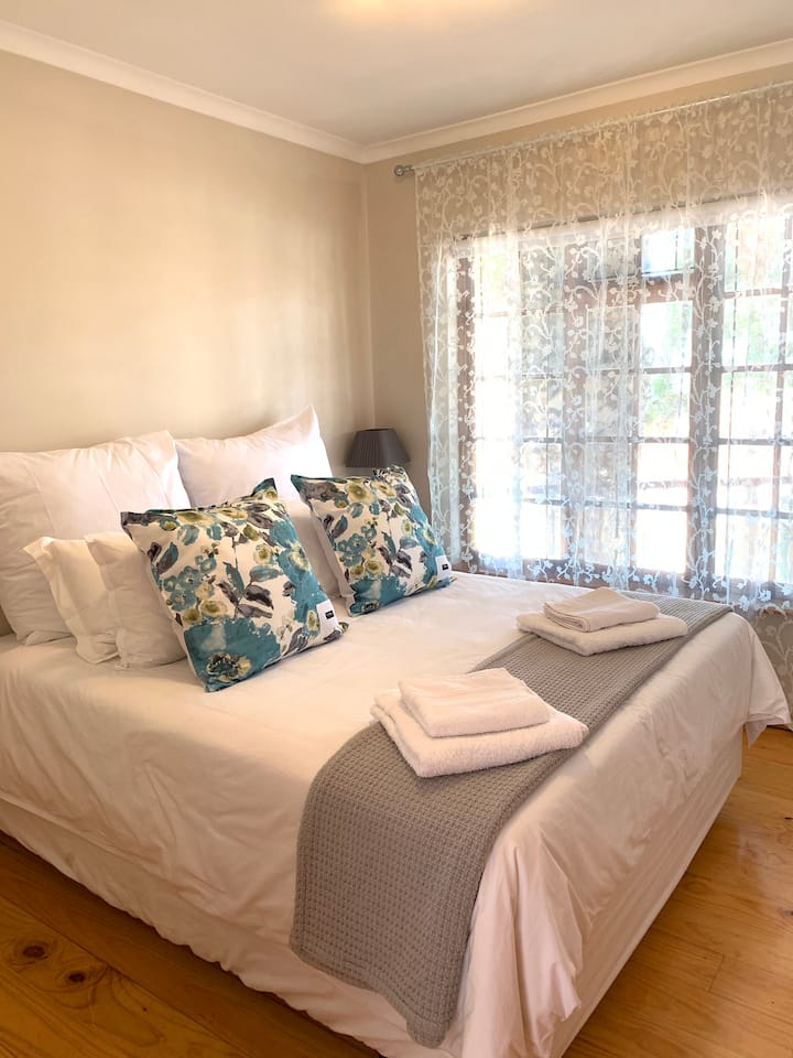 Main Bedroom with Queen size bed, bedside table and 3 cupboards.
