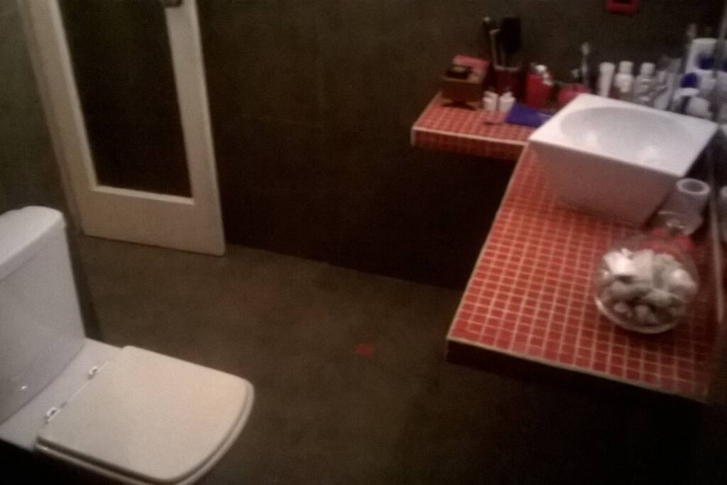 Éste es un amplio baño con un gran espejo.