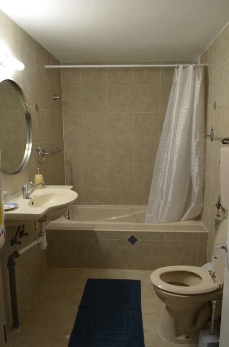 The bathroom has a bathtub with a shower