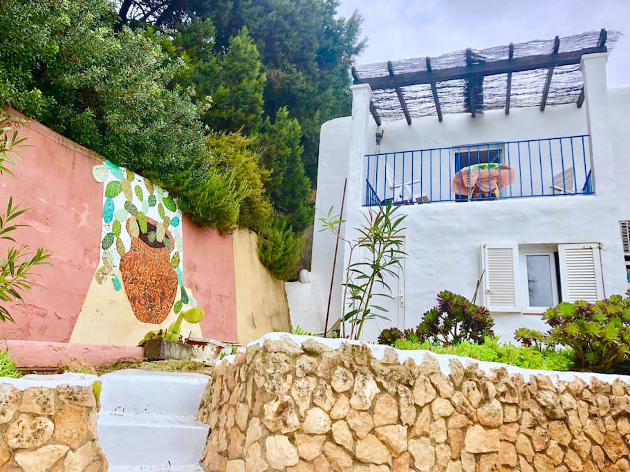This side of the house faces the ocean. This is your balcony with a view over te park of the main house and your sea-view. You do have access to the beach. You don’t have access to a pool.
Casita: your private house & private parking. You see the main building. But only the little house called Casita, is your place to stay.
