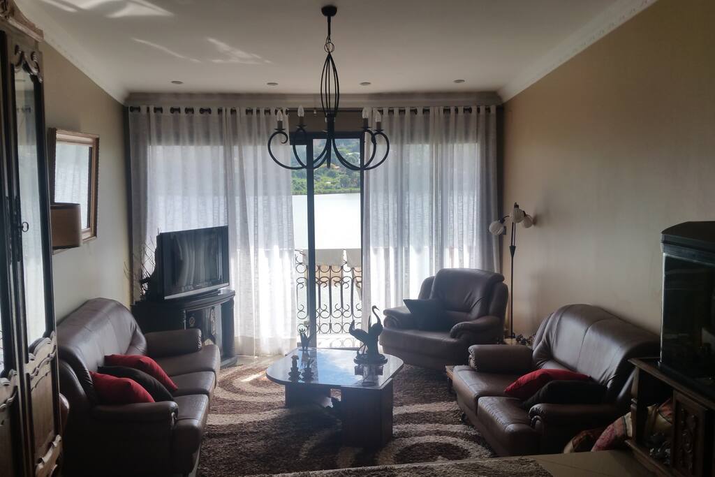 Salon douillet avec une large baie vitrée permettant une belle vue sur le lac. Balcon longeant le salon et la chambre.