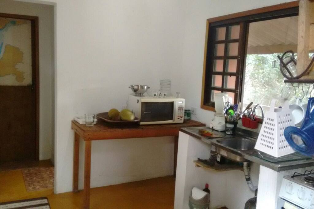A nossa cozinha vista da porta de entrada, a porta fechada com uma carta náutica decorando é a porta do quarto!