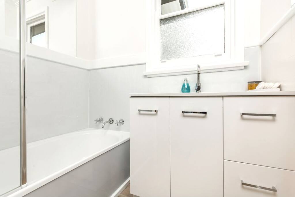 Bathroom, newly renovated, with soaps, shampoo, hairdryer, towels.