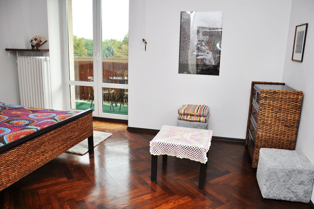 In bedroom there are two pouffs, small coffee table and cabinet with drawers.