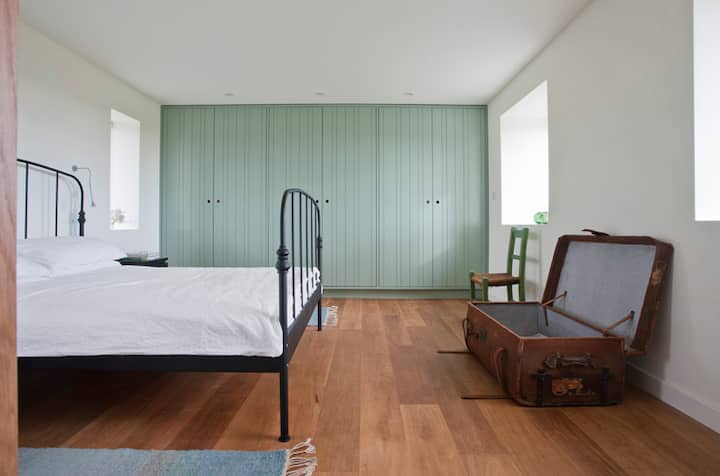 Chambre Murvey, lit king size, il y a maintenant une robe en bois à la place du coffre