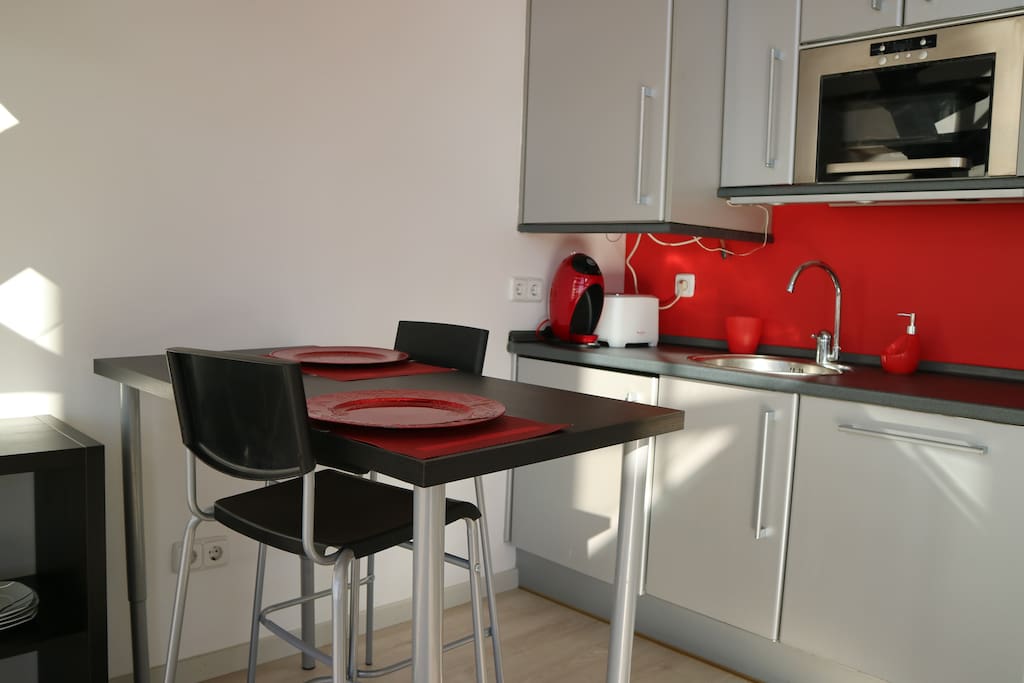 Cocina con zona de desayuno con mesa alta.