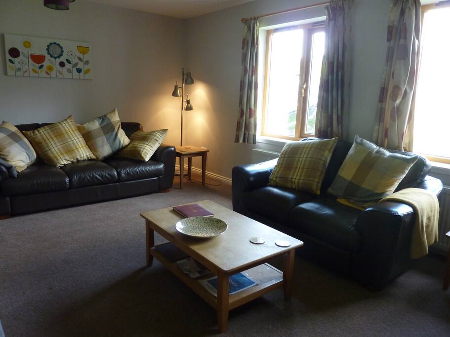 Spacious lounge with large cushions and throws.