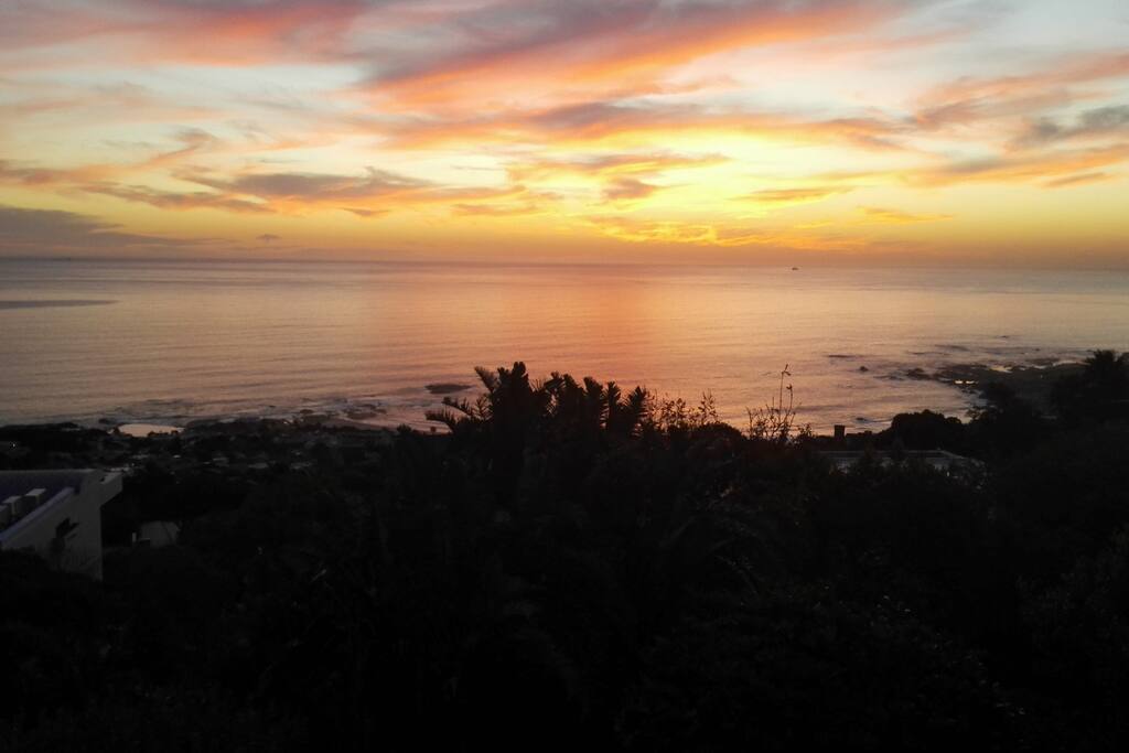 A view of the sun setting over the sea from the bedroom door