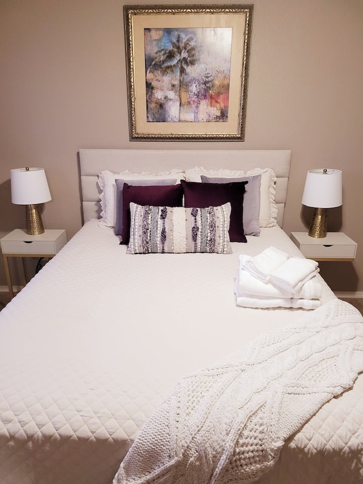 Nivel superior principal. Dormitorio principal. 
Una vista más cercana de la cama con toda la ropa de cama nueva, colchón con cremallera y protectores de almohadas, una funda de edredón con una manta baja, una manta de felpa suave o una manta acolchada, además de muchas almohadas y un tiro. 