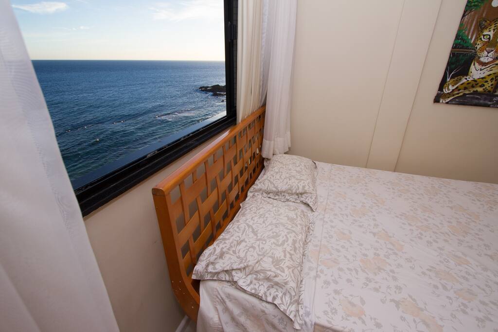 Quarto com cama de casal e vista mar.