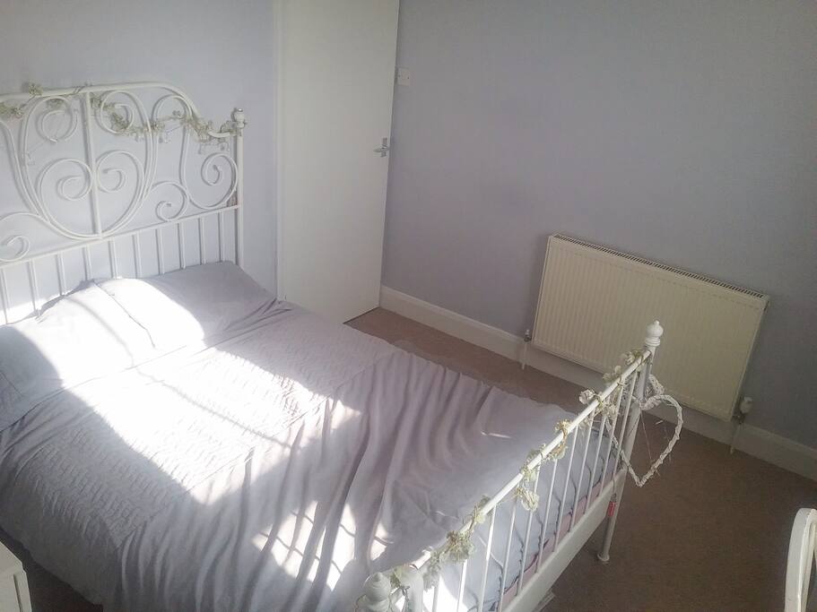 Private room with double bed, storage box space and clothes rail.
