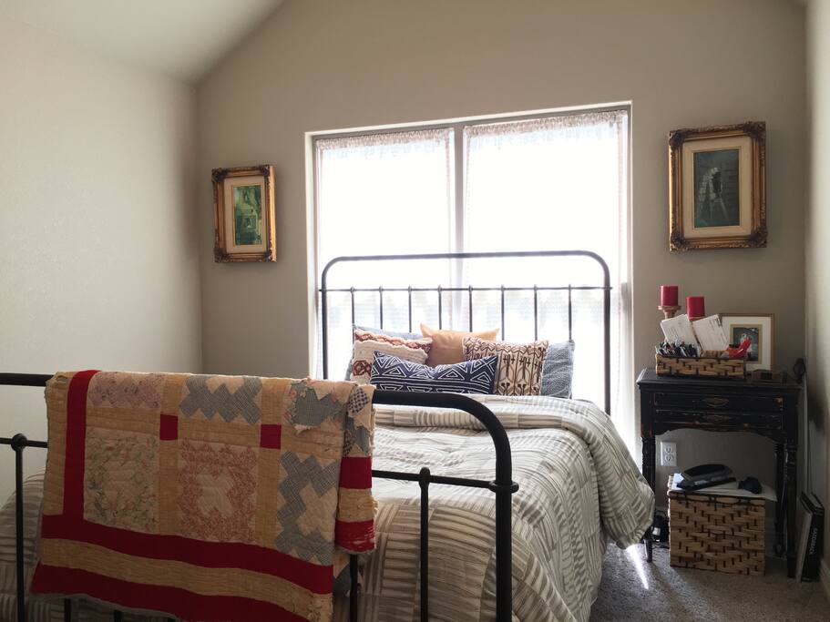 Guest bedroom with queen bed, dresser and chair.