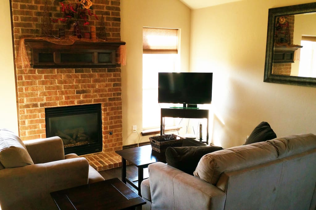 Gas fireplace and hand-scraped wood floors in den