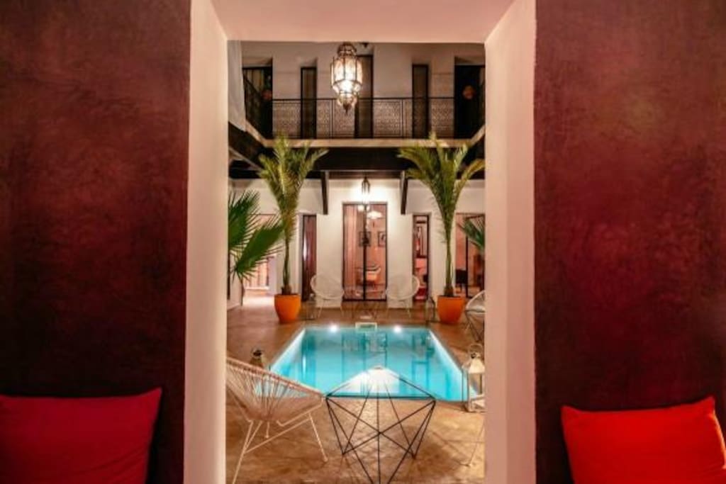 Vue du patio depuis le salon d'été, ouvert sur la patio et sa piscine