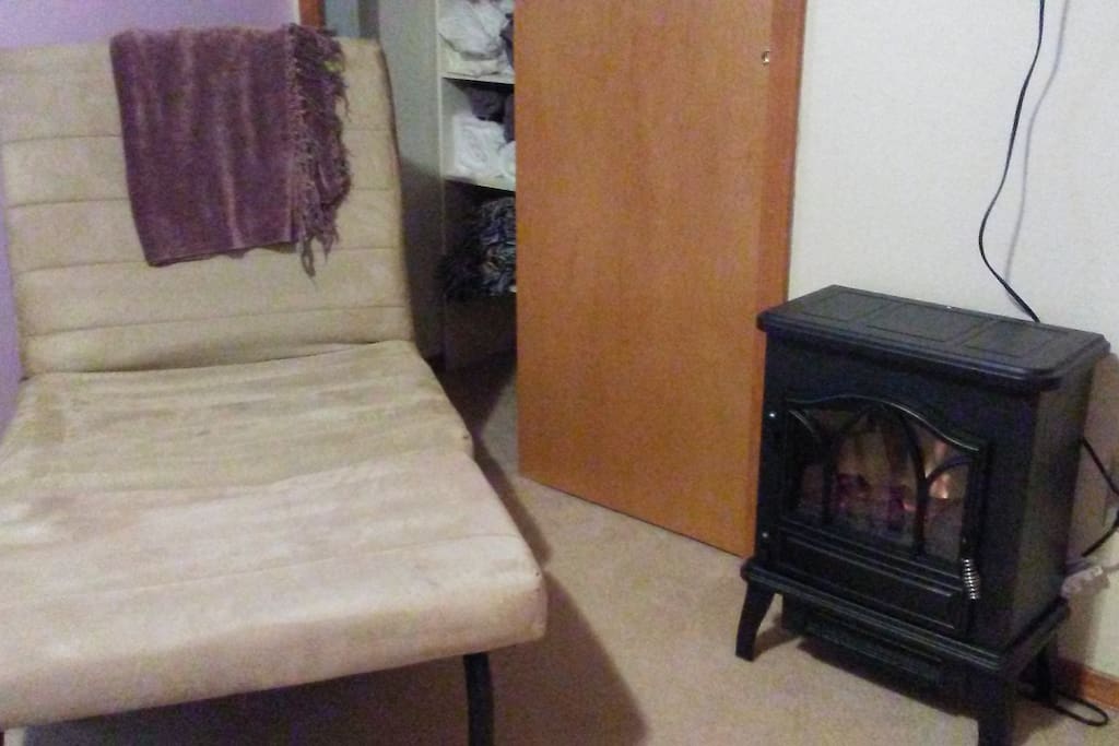 Extra blankets, a cozy fireplace heater, and chaise lounger