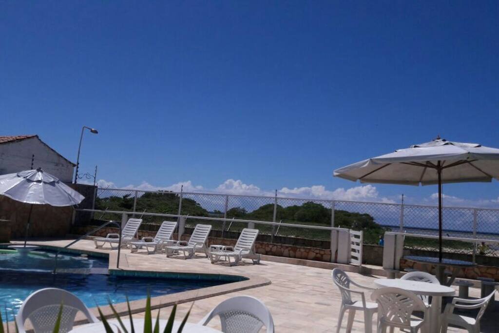 foto da piscina com área de lazer vista beira mar