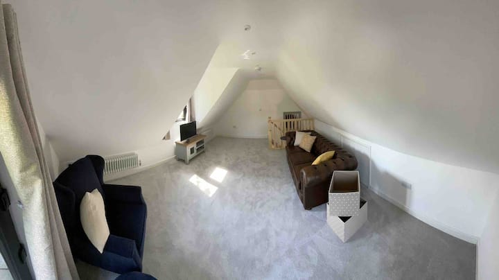 Eneo la kupumzikia lenye kitanda kikubwa cha sofa na viti vya mikono