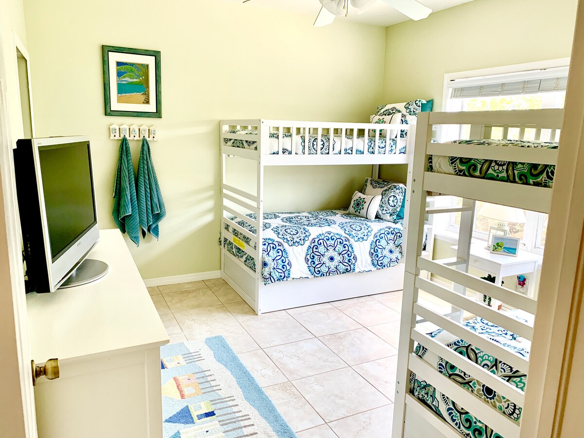 غرفة نوم في الطابق الثاني مع سريرين بطابقين وسريرين متحركين.