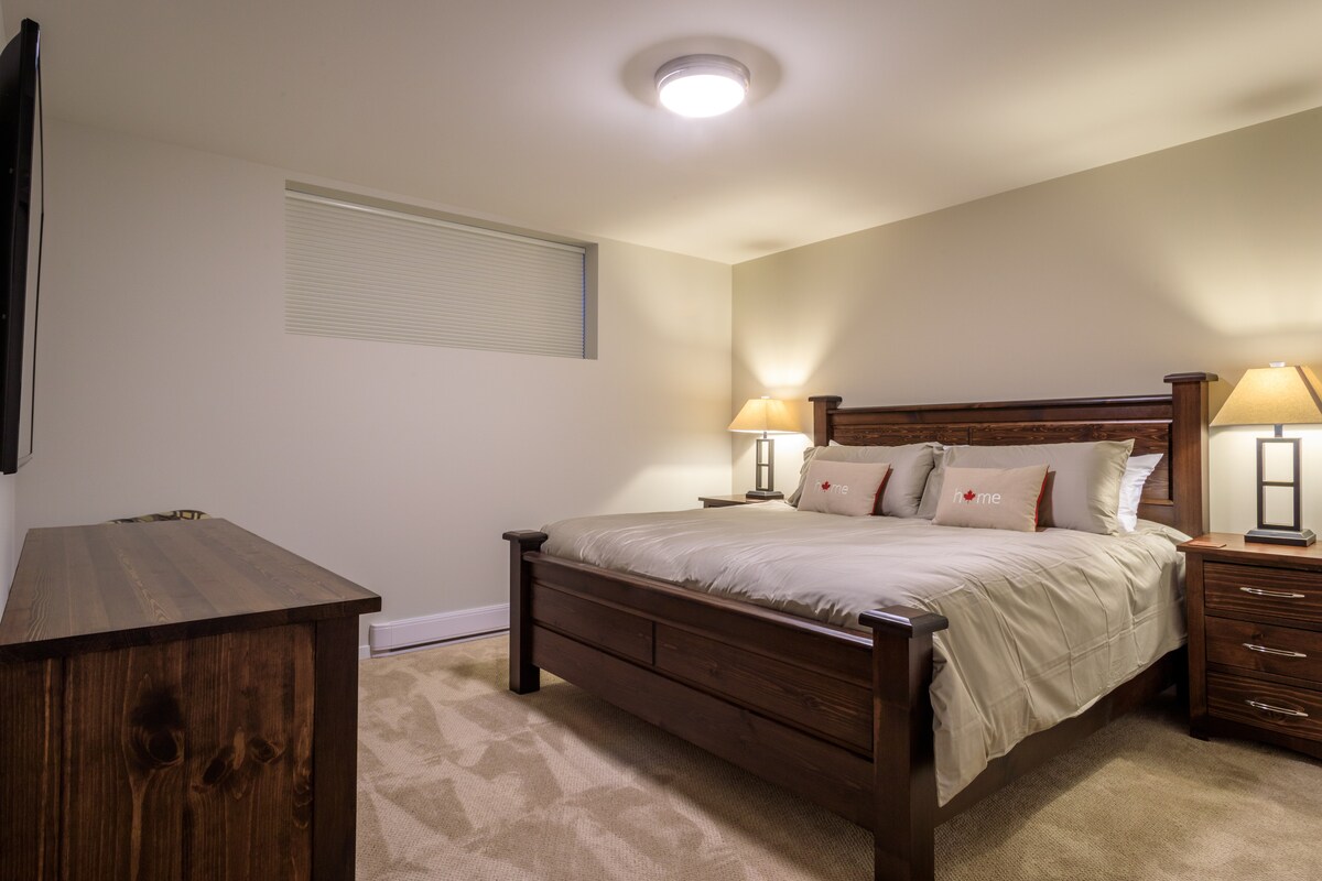 חדר שינה למטה עם מיטת קינג סייז, מצעים איכותיים, שידה, שולחנות צד, מנורות, טלוויזיה בלווין, BluRay palyer וארון גדול.