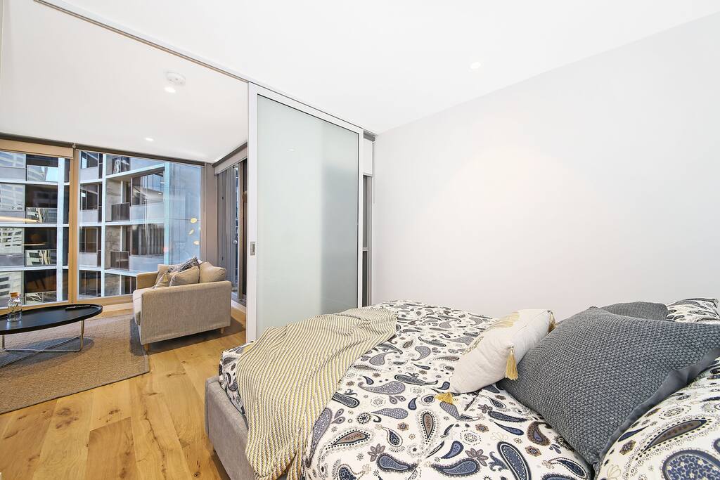 The bedroom with a queen sized bed & plush pillows.