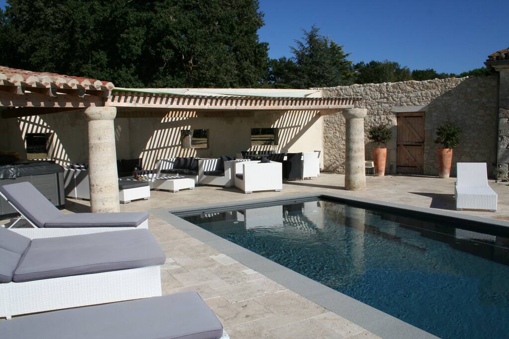 Une piscine, un salon à l'ombre