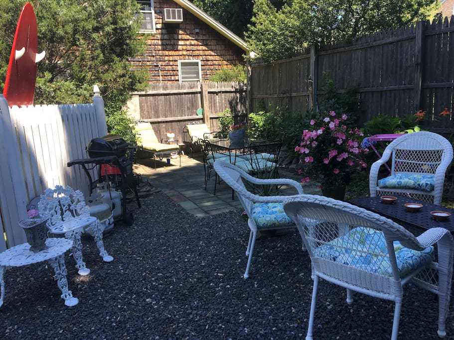 Private fenced in patio with multiple seating areas and grill.